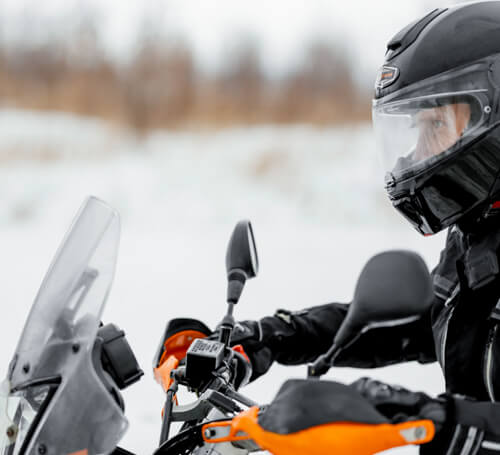 Motorcyclist riding through snow.
